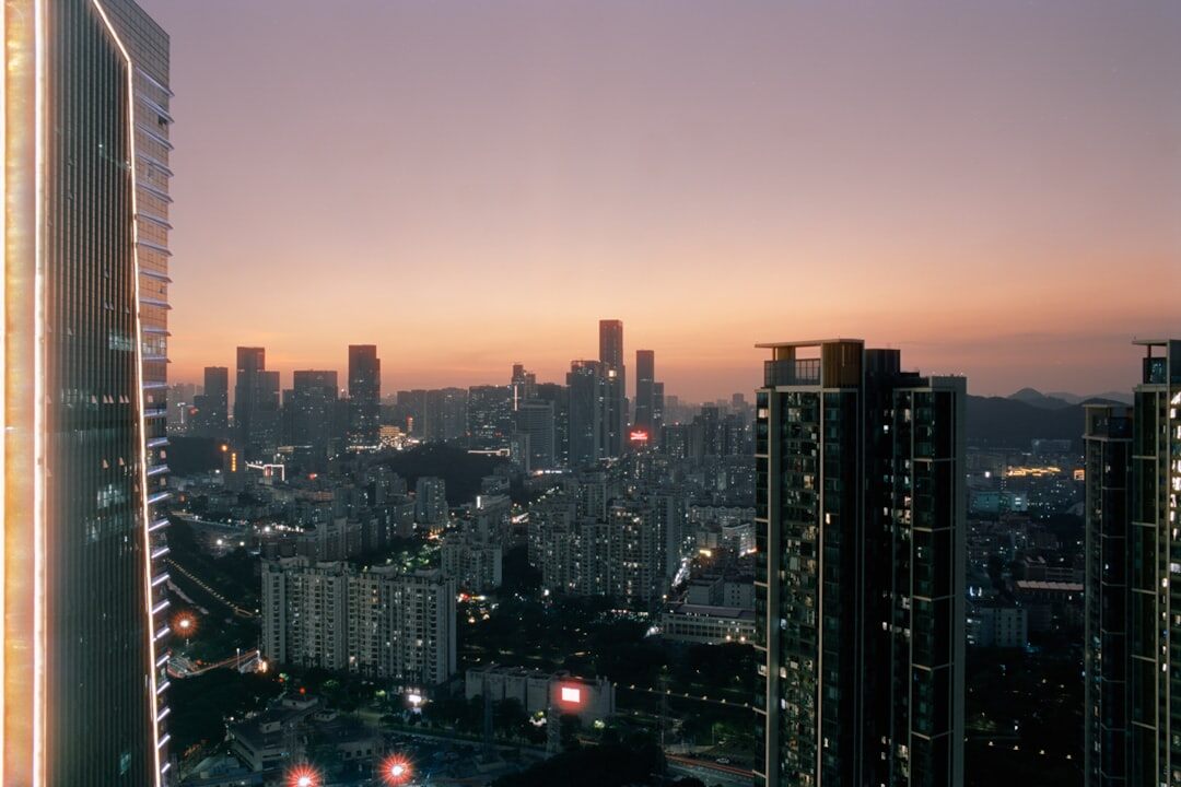 Editorial office with large windows overlooking a city skyline at dusk