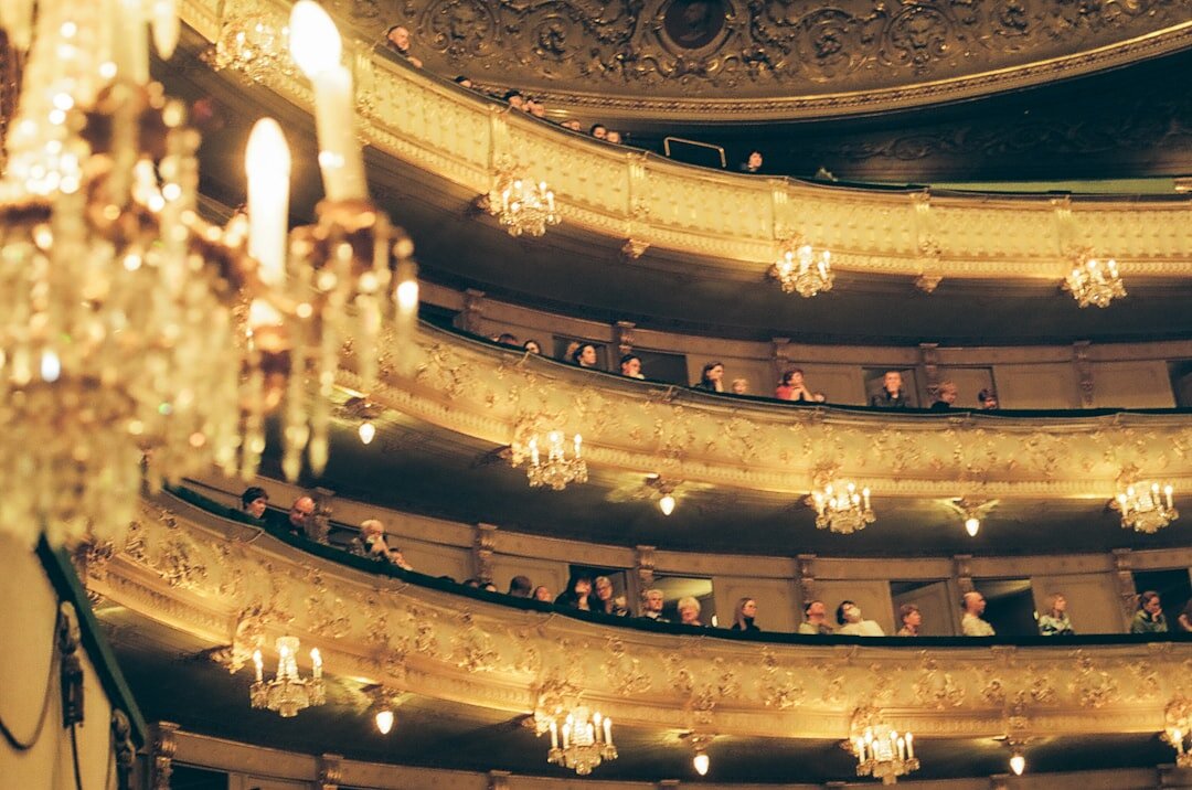 Grand opera house interior with ornate balconies and warm gold lighting